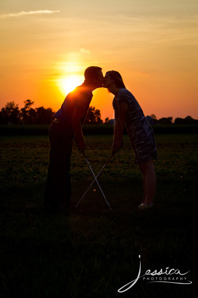 Engagement Pic of Jeremy Miller & Jennifer Watson golfing kiss with sunset
