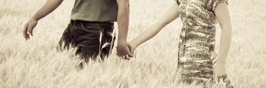 Engagement Pic of Jeremy Miller & Jennifer Watson walking in wheat field