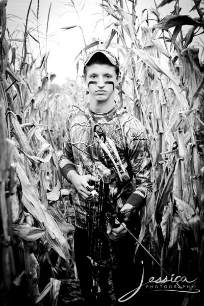 Senior Portrait of Tyler Headings with Camo and Bow in Corn