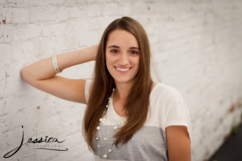 Senior Portrait of Michaela Hershberger with a white brick wall