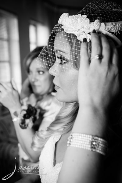 Pic of bride putting on birdcage hat