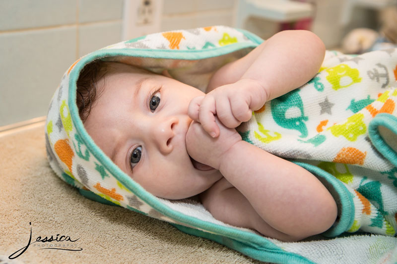 Pic of baby sucking thumb and wrapped in towel 