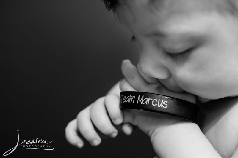 Picture of baby holding cancer fight wristband