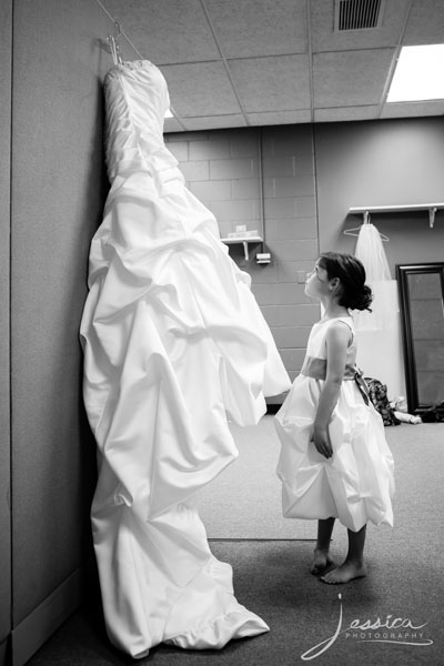 Picture of flower girl looking at the bride's dress