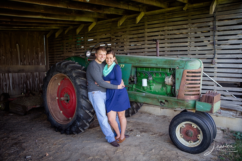 Engagement of Sheldon Yoder and Rebecca Lawrence beside an old tractor