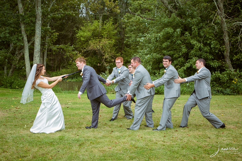 Bride and groomsmen playing tug-o-war with groom