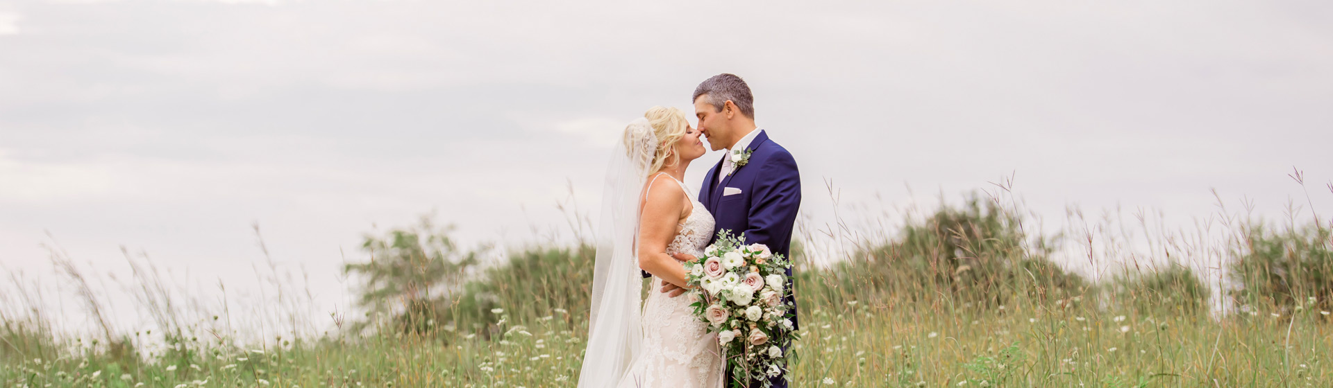 Bride and Groom in a long grassy field with Queen Anne's Lace